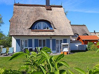 Ein großes Gartenhaus, ein Grillkamin, eine Fasssauna und ein Strandkorb gehören zum Garten.